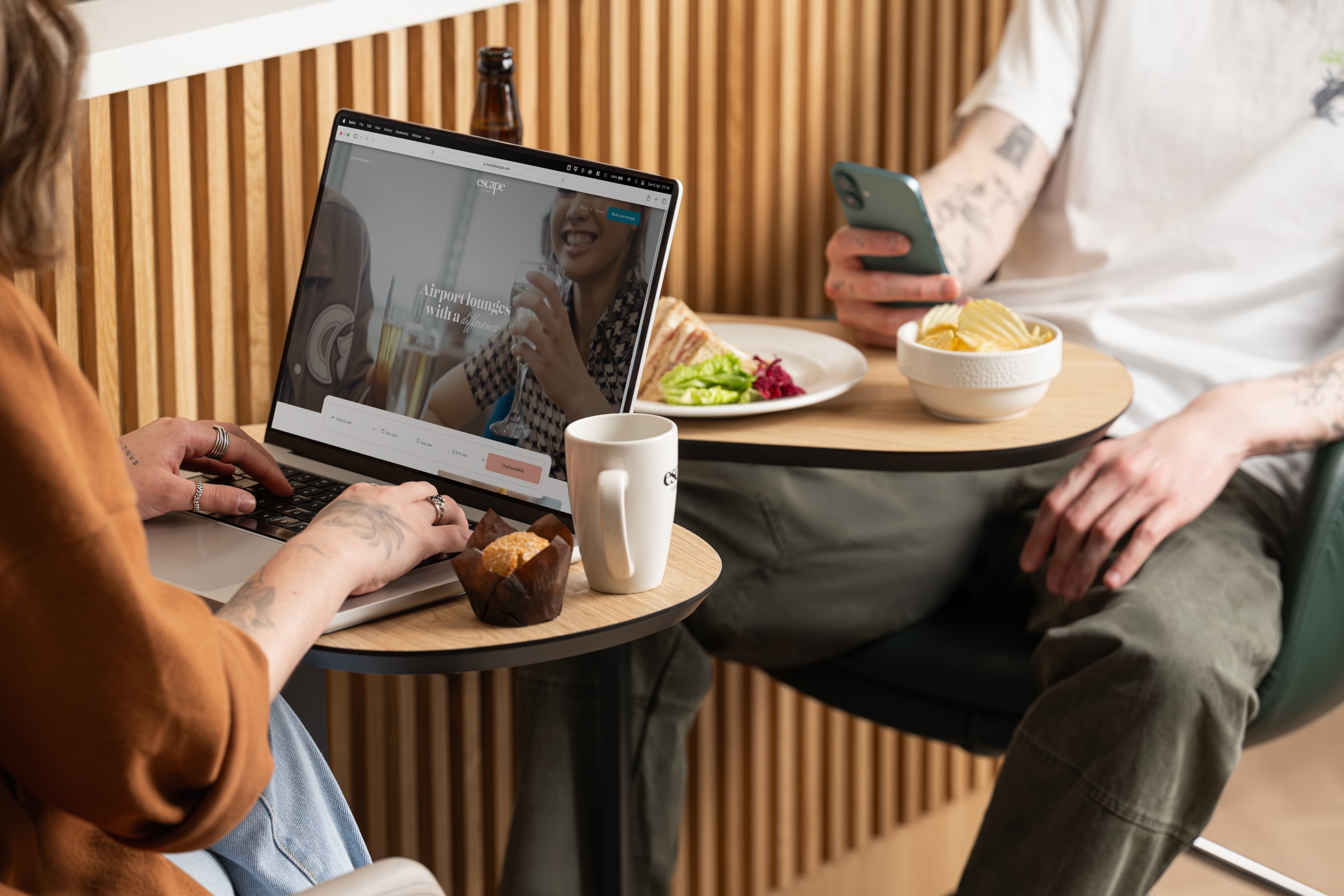 Two people sat at table with laptop and food