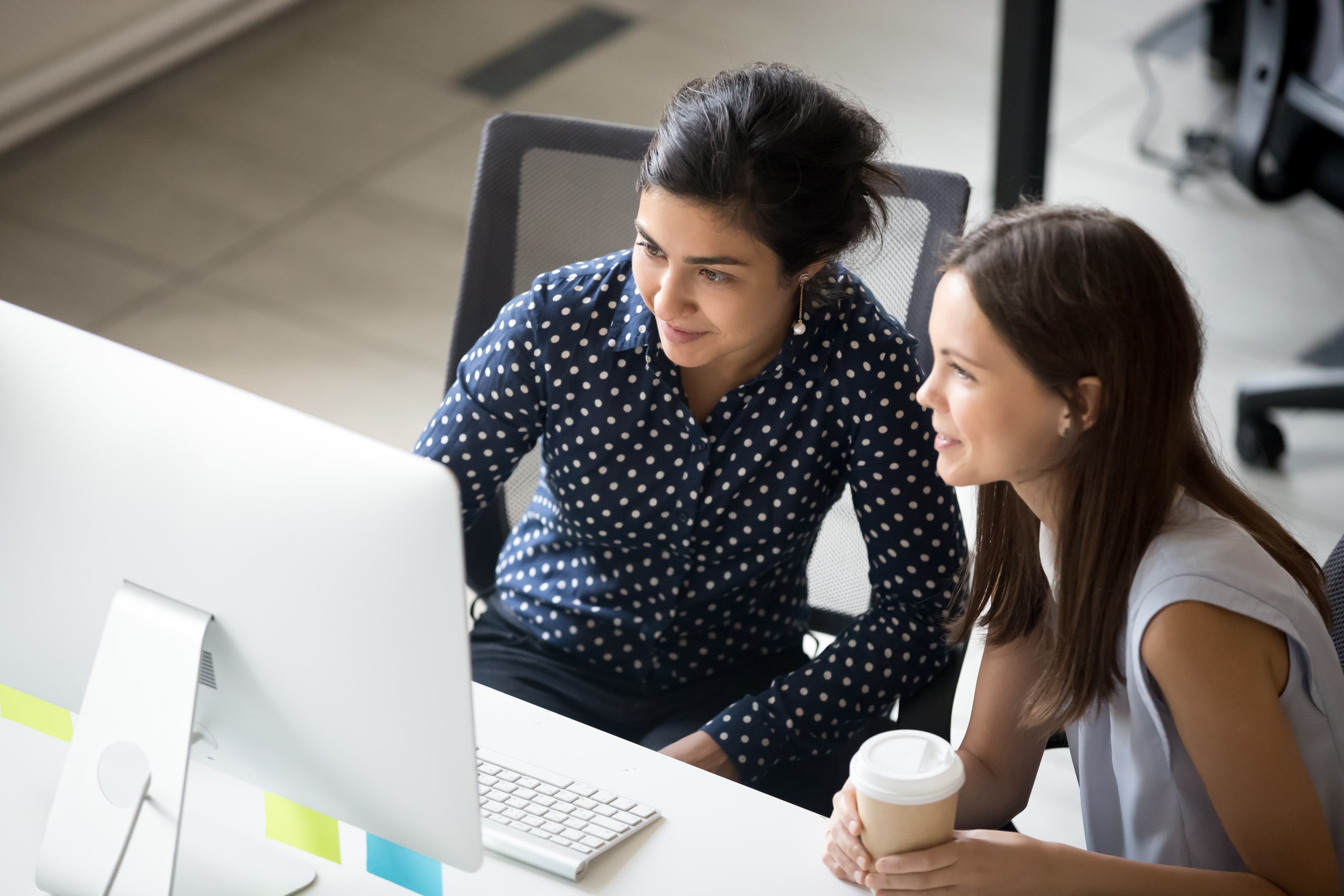 Two women sat looking at computer screen
