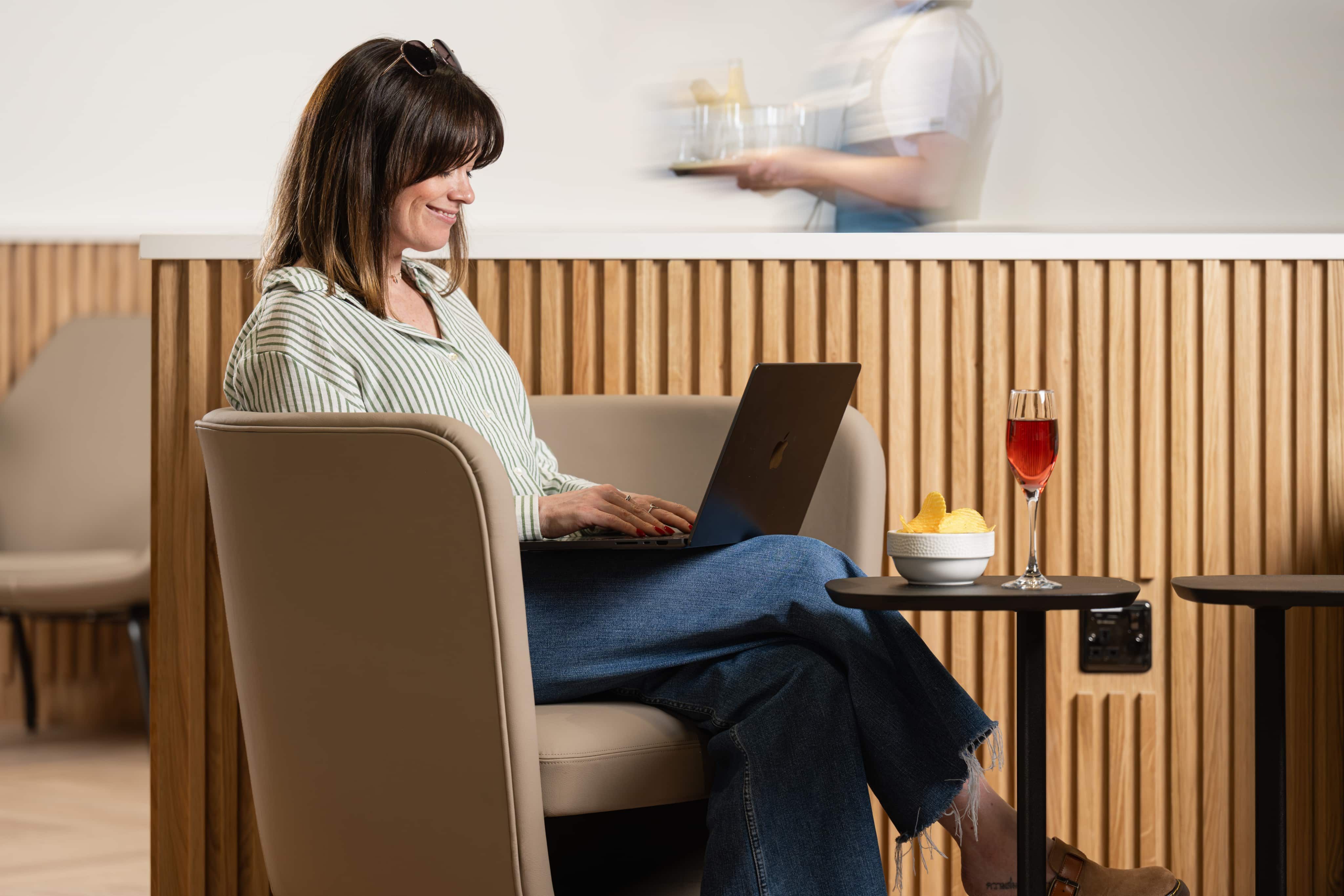 Woman on laptop in airport lounge
