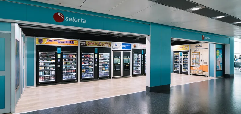 A Selecta vending area with various snack and drink machines in a brightly lit, open space.