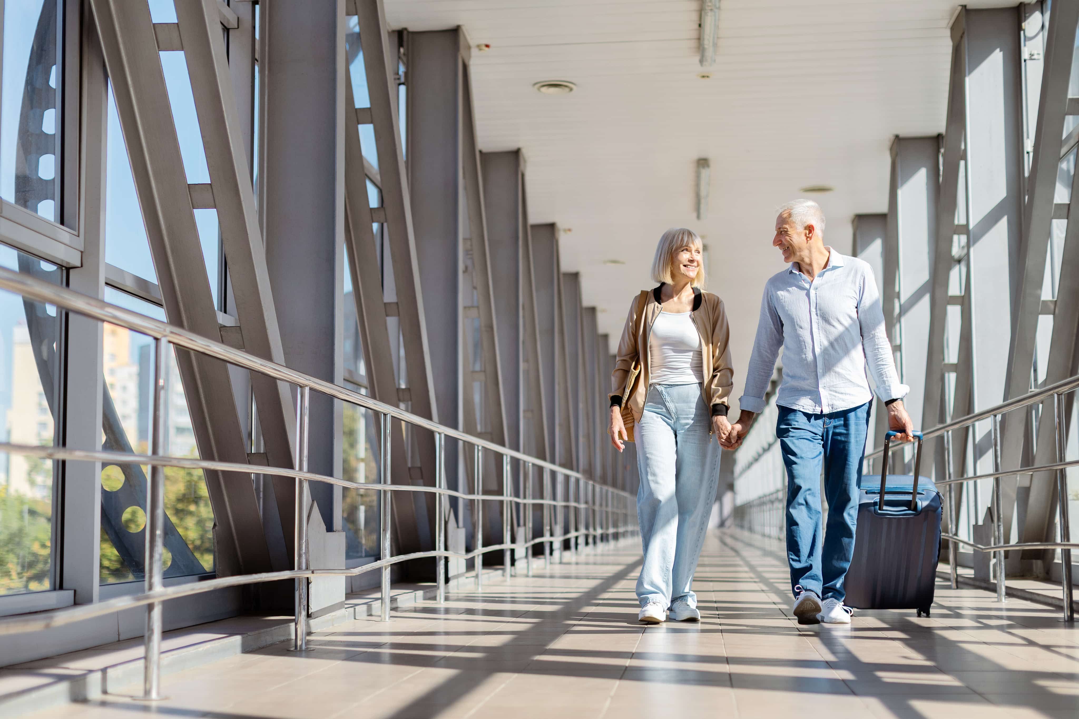 Couple holding hands walking through airport