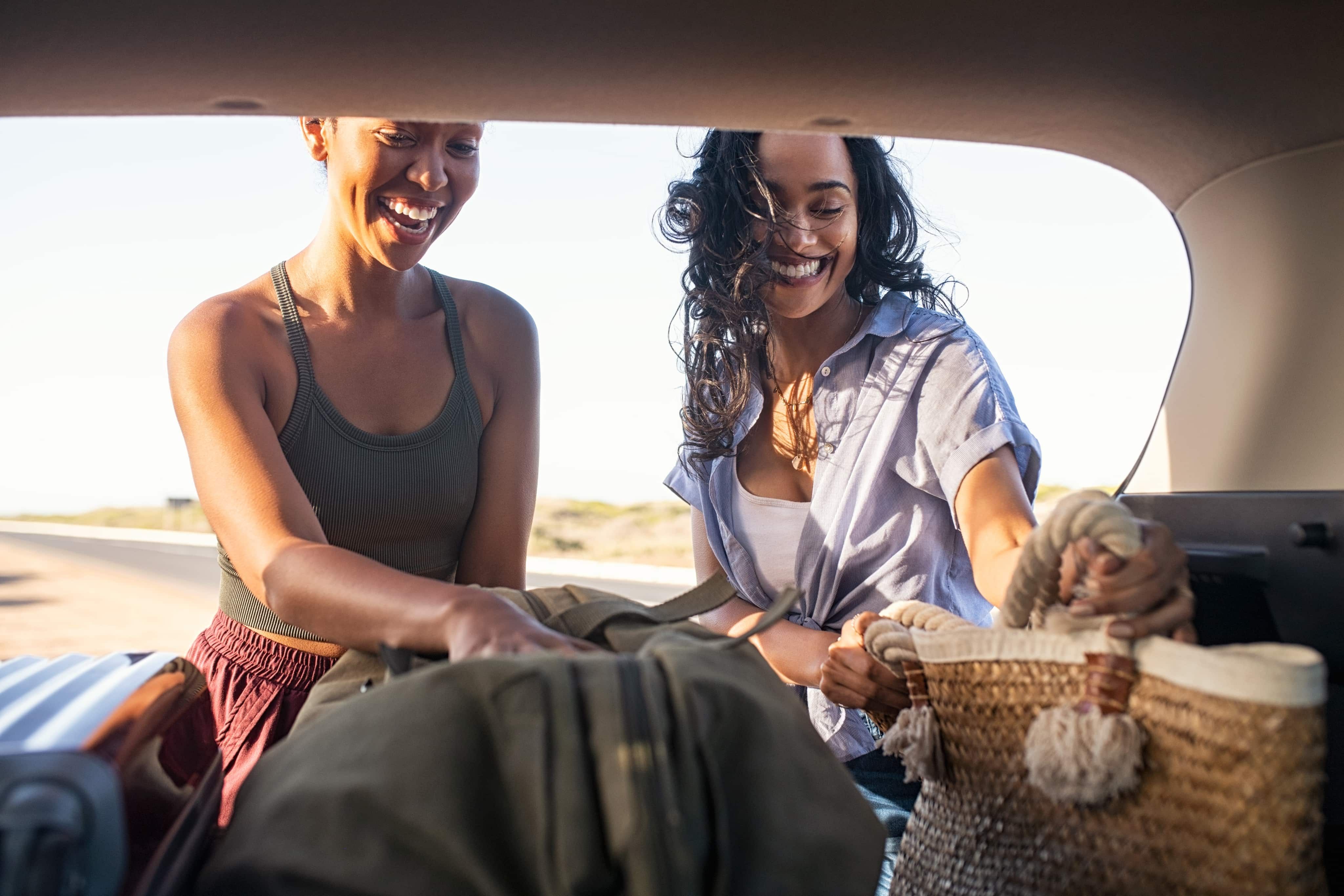 Two women getting luggage out of car