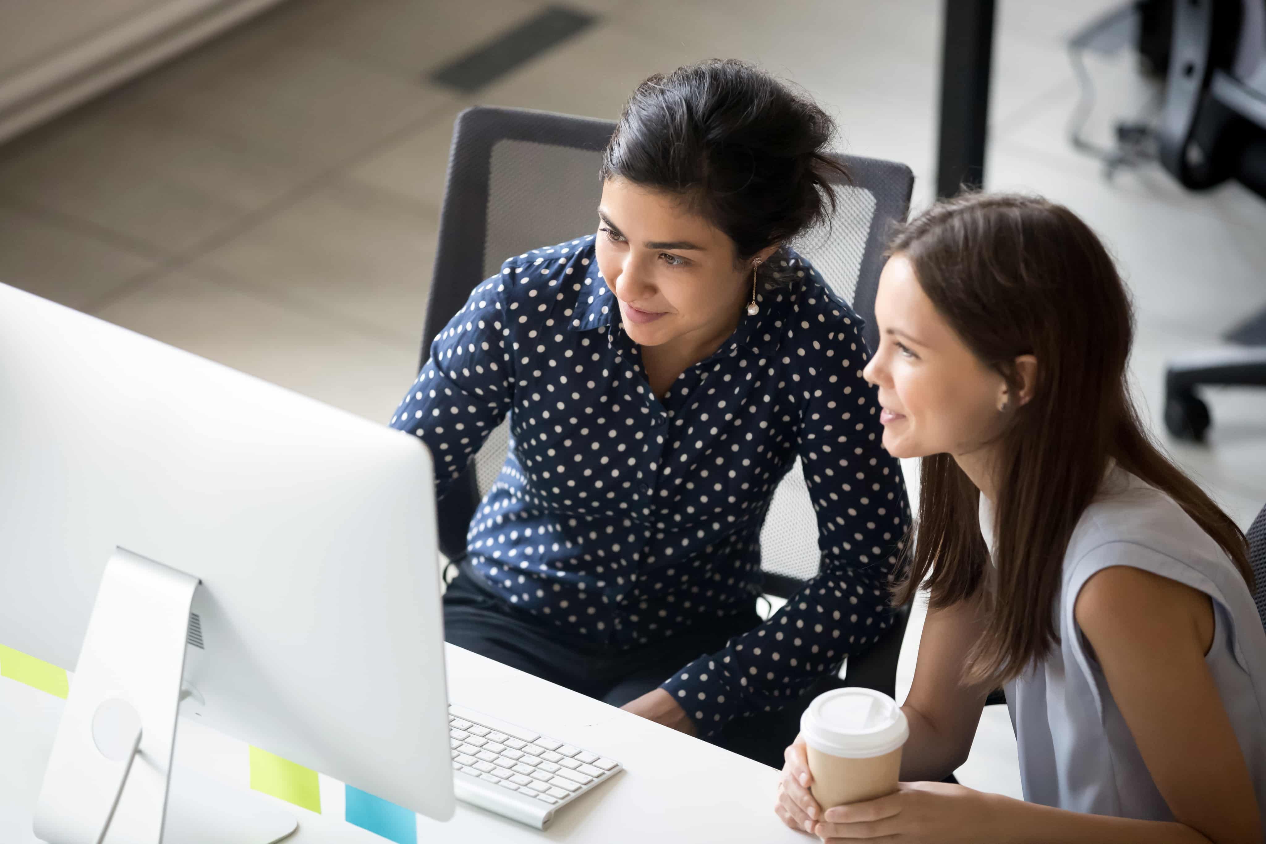 Two people sitting in front of a computer