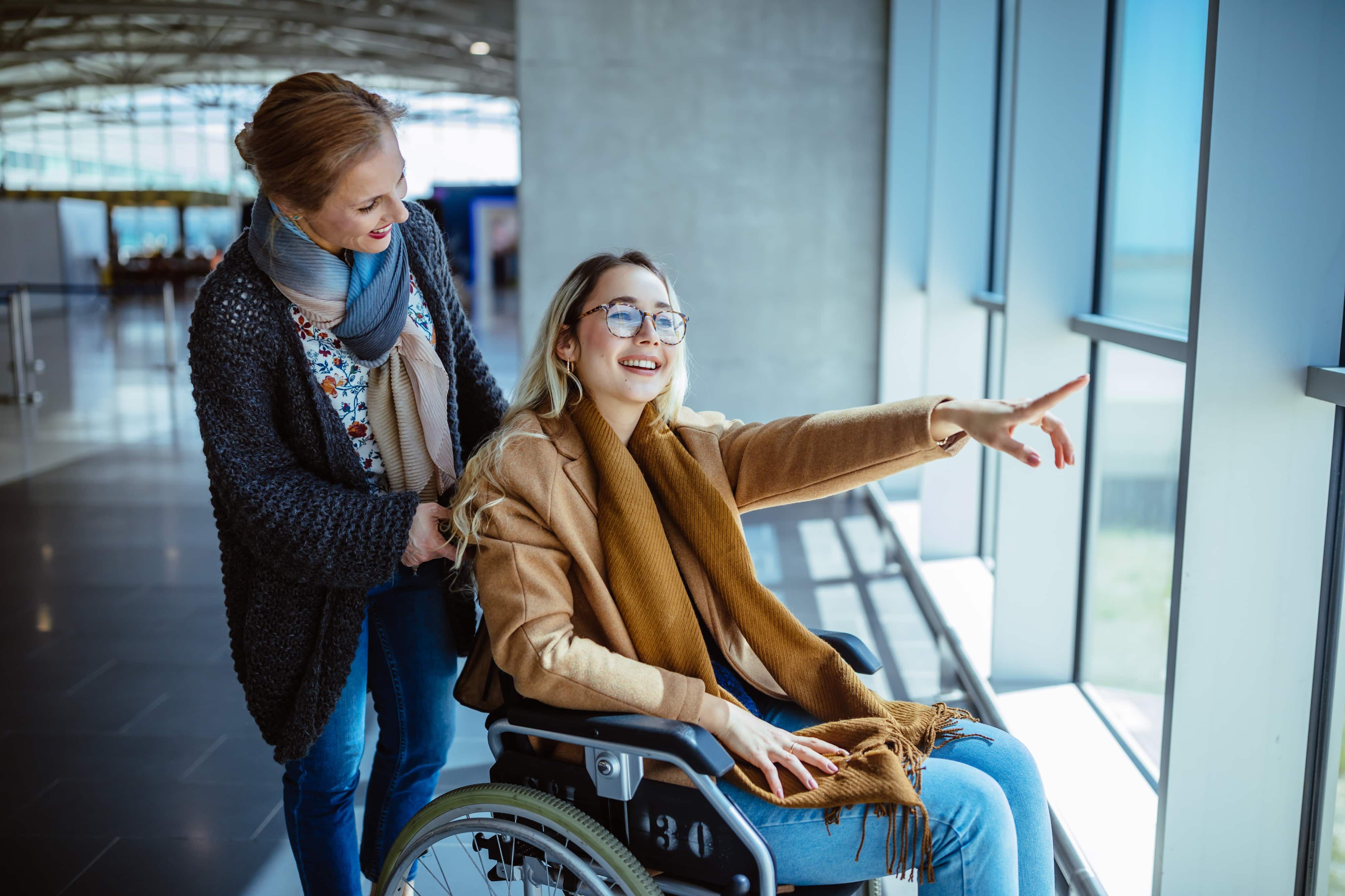 Woman in wheelchair pointing out of window