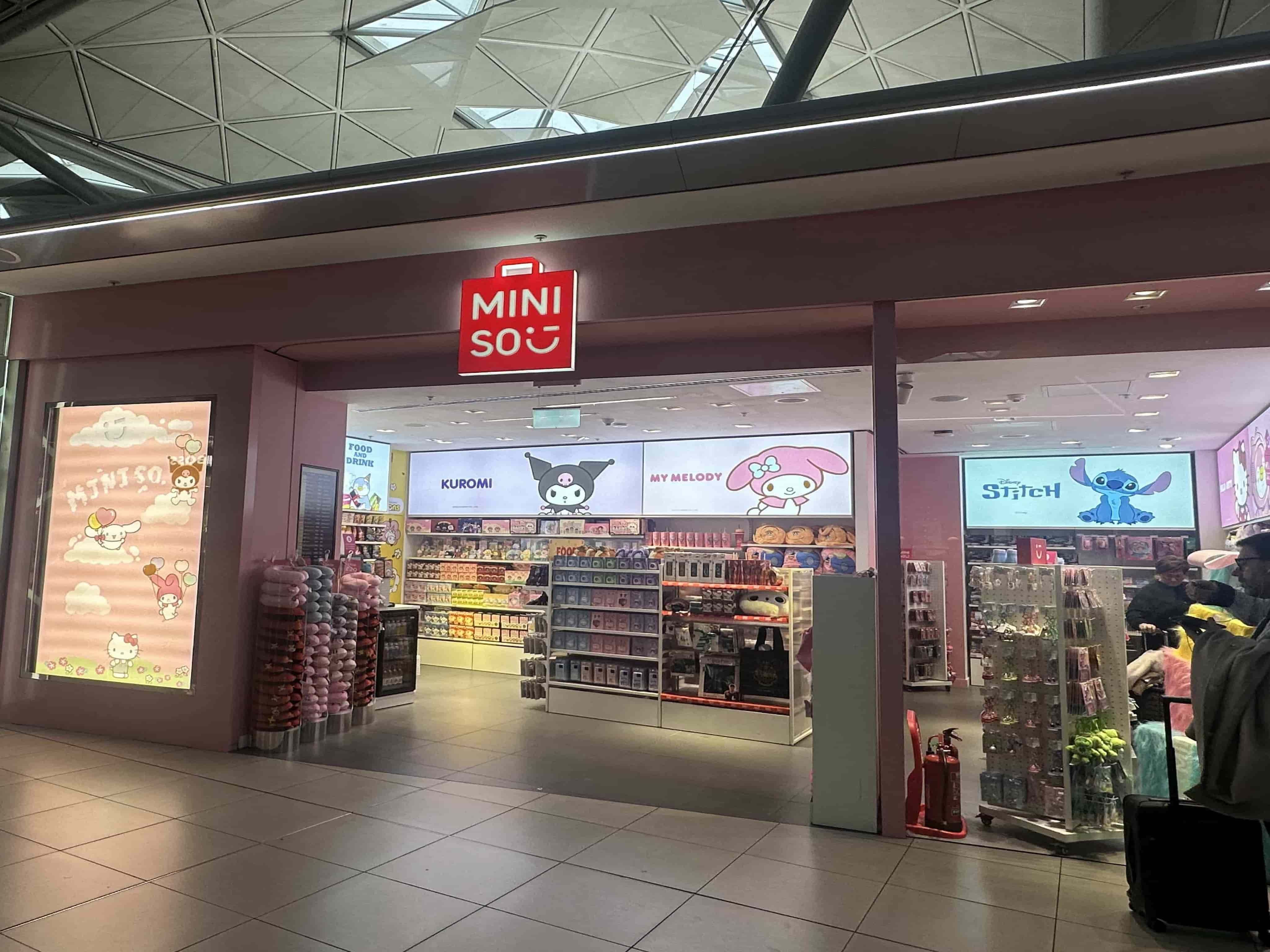 A Miniso store with brightly lit displays featuring character-themed merchandise. Signs for Kuromi, My Melody, and Stitch are visible.