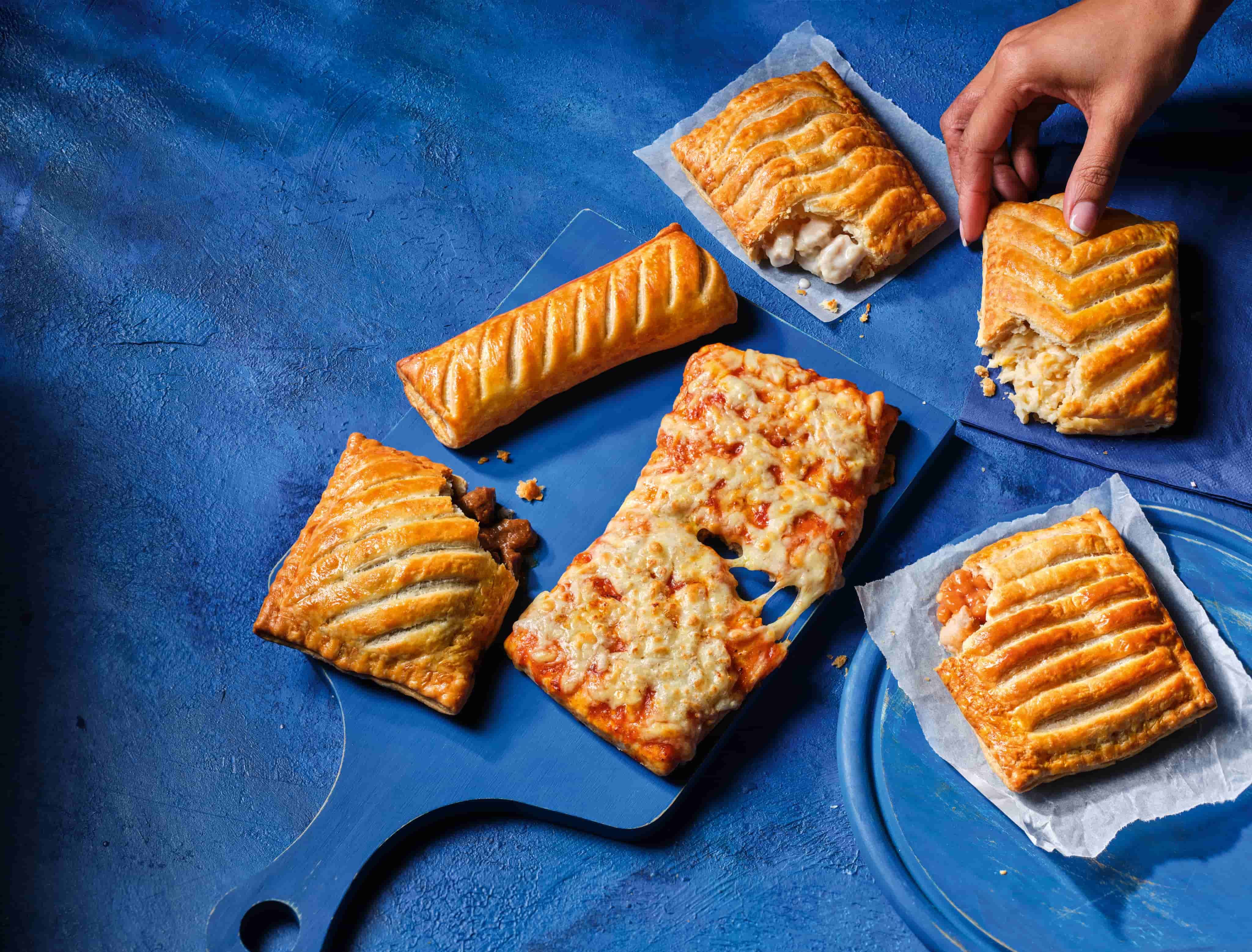 A selection of pasty's on blue background at Greggs