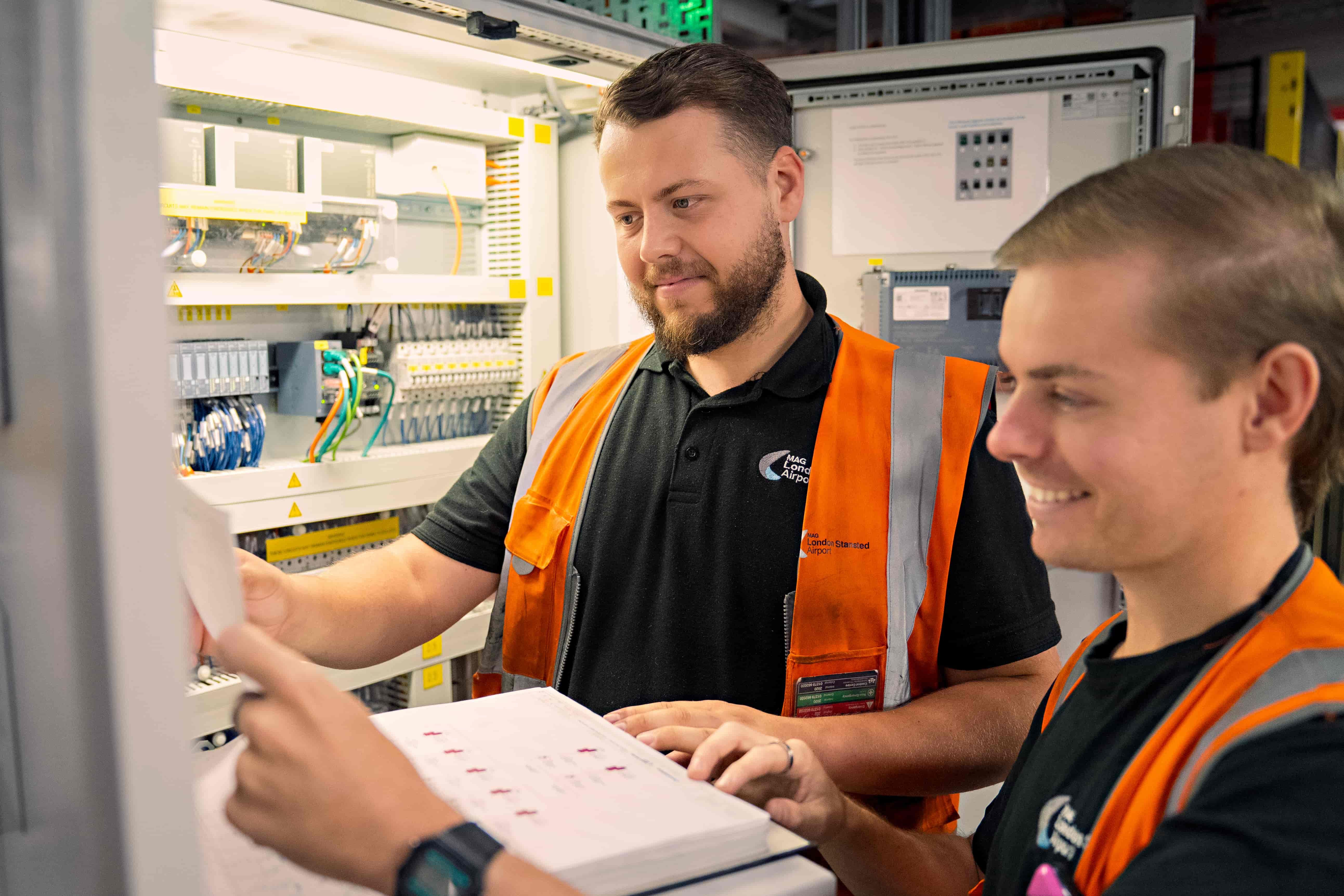 Two men in high vis jackets sorting wires
