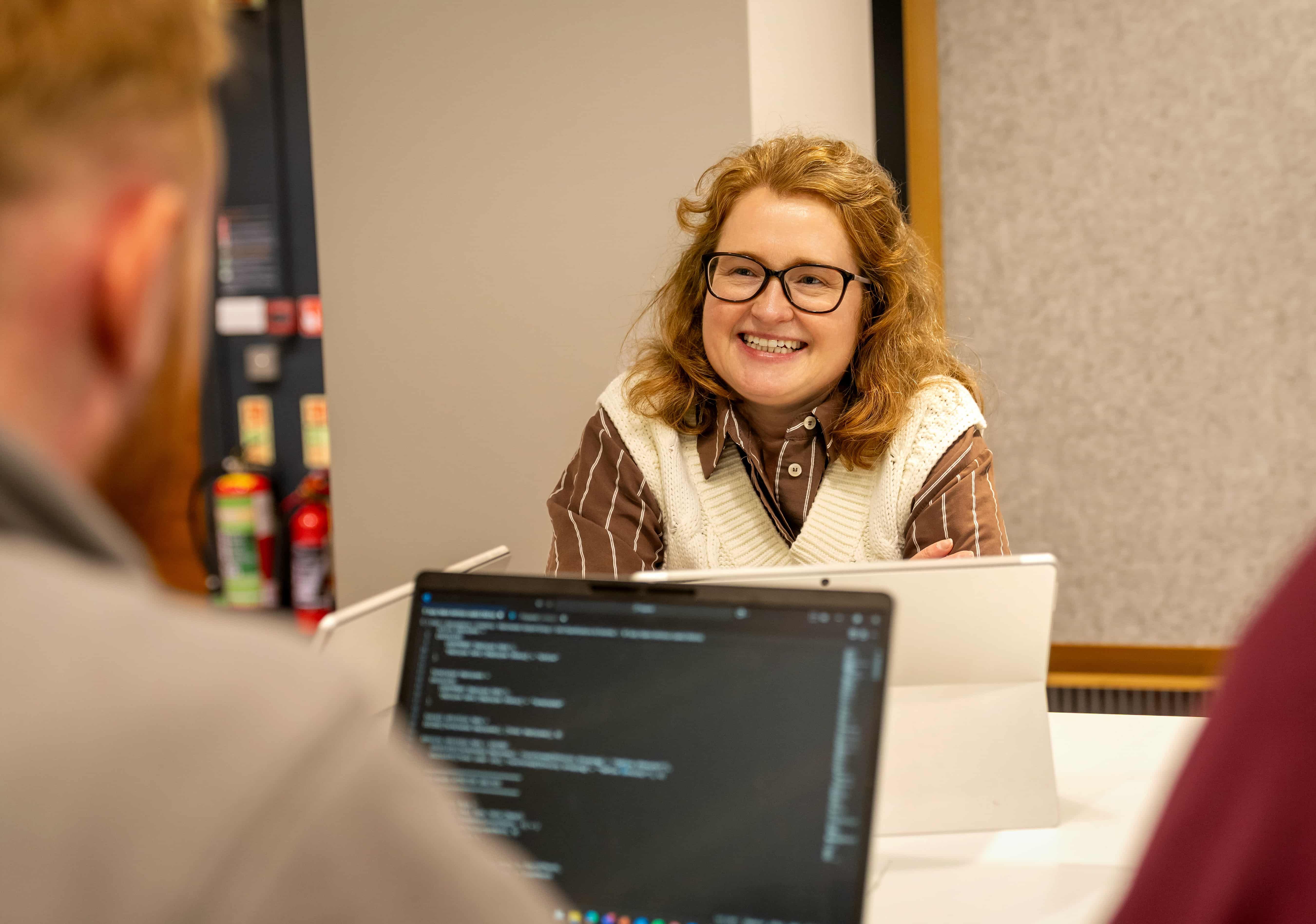 Two people with a computer showing code