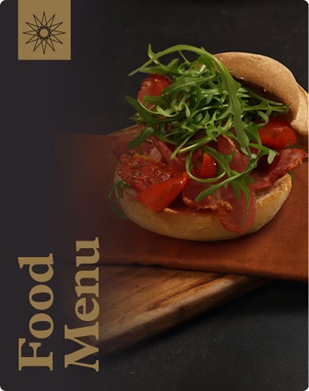 A sandwich with sliced meat, cherry tomatoes, and arugula on a wooden board. The words "Food Menu" are on the left.