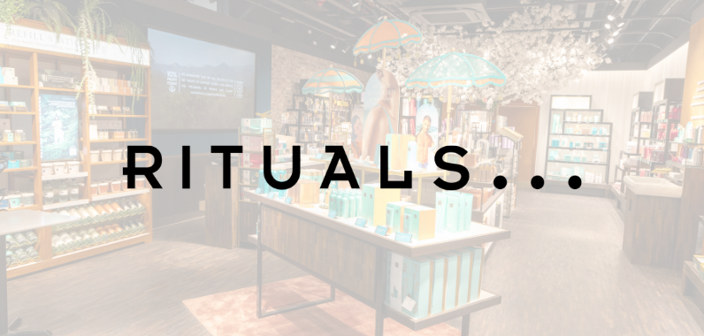 Store interior with decorative umbrellas and shelves of products, featuring the word "RITUALS" prominently over the scene.