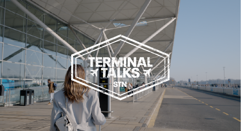 A person walks outside an airport terminal on a sunny day. The text overlay reads, "Terminal Talks STN."