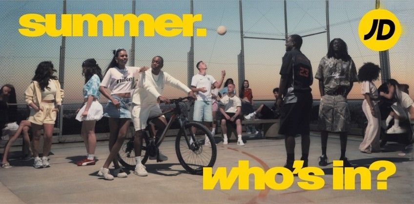 Group of young people enjoying summer activities on a rooftop court, featuring a bicycle and a volleyball, with bold yellow text overlay.