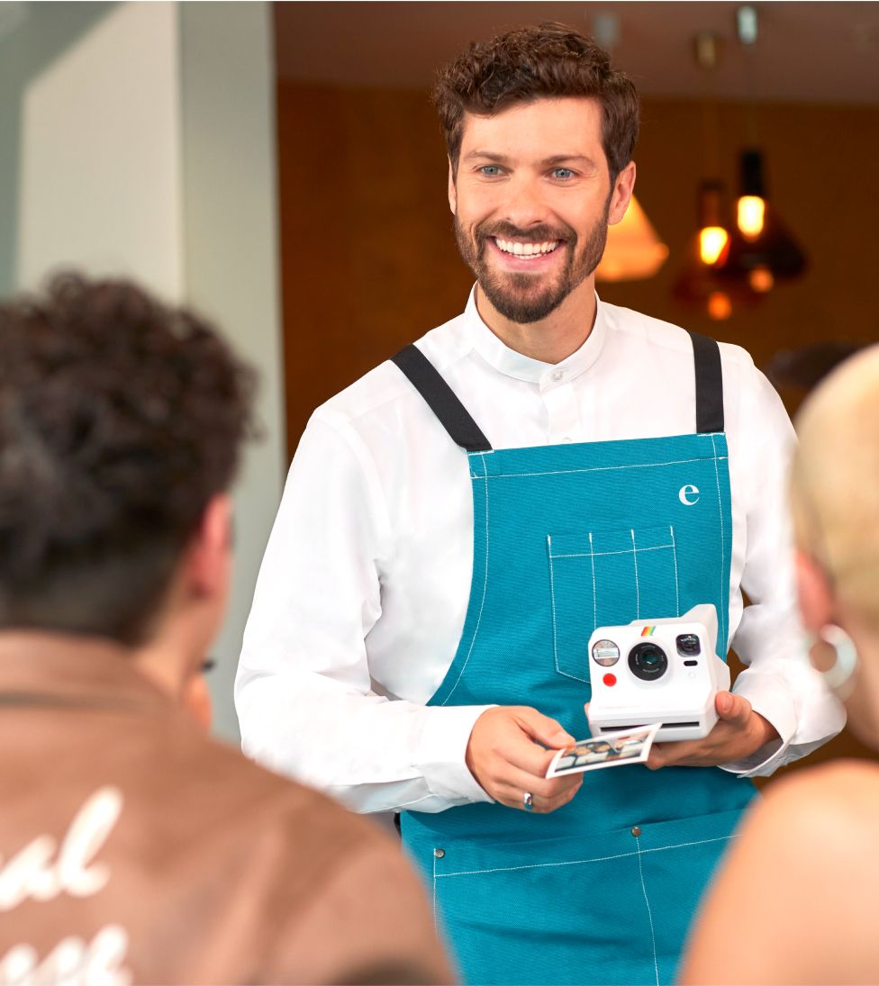 a staff member taking a photo for a couple in the lounge on a camera